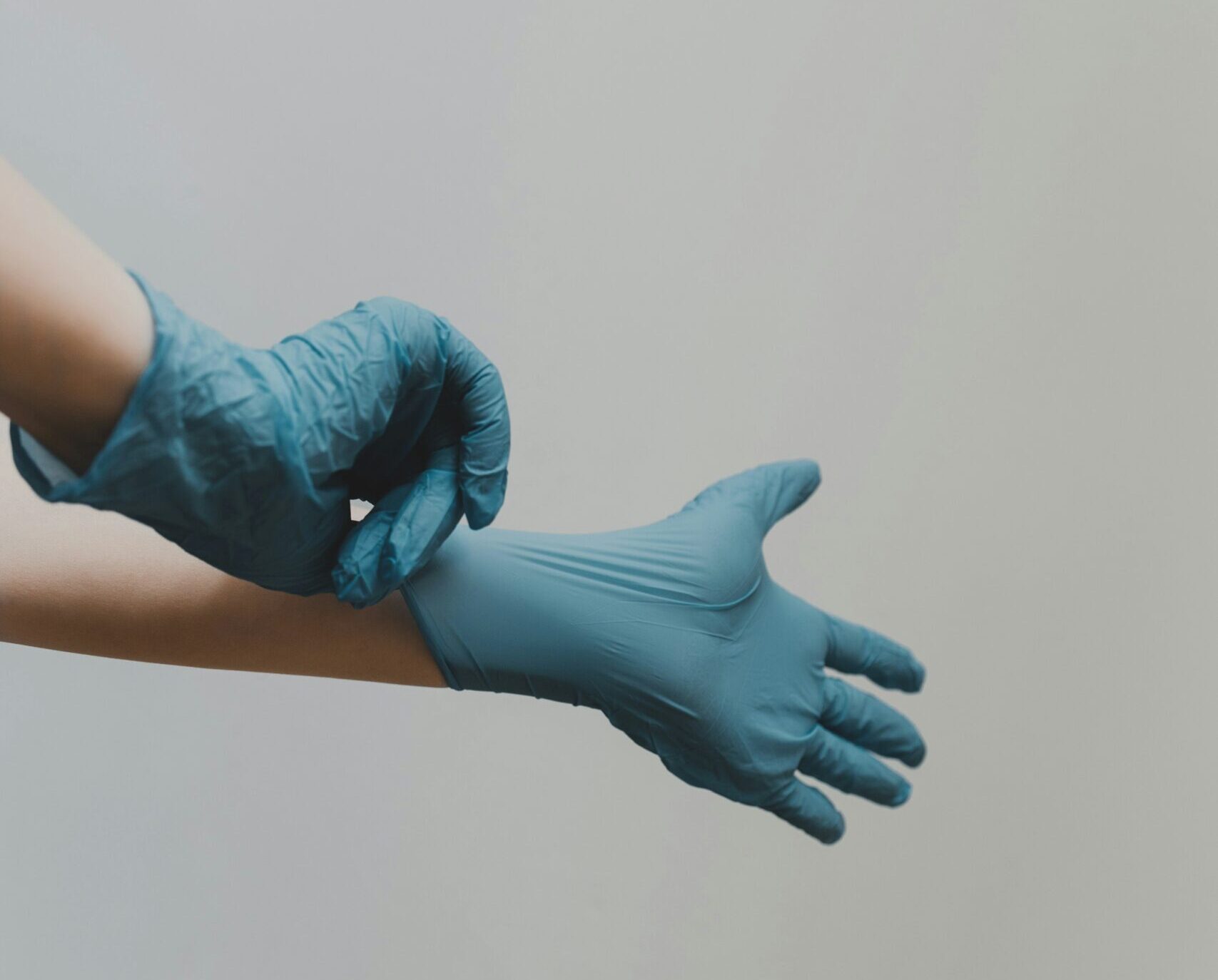 Person zieht sich Silikon Handschuhe über